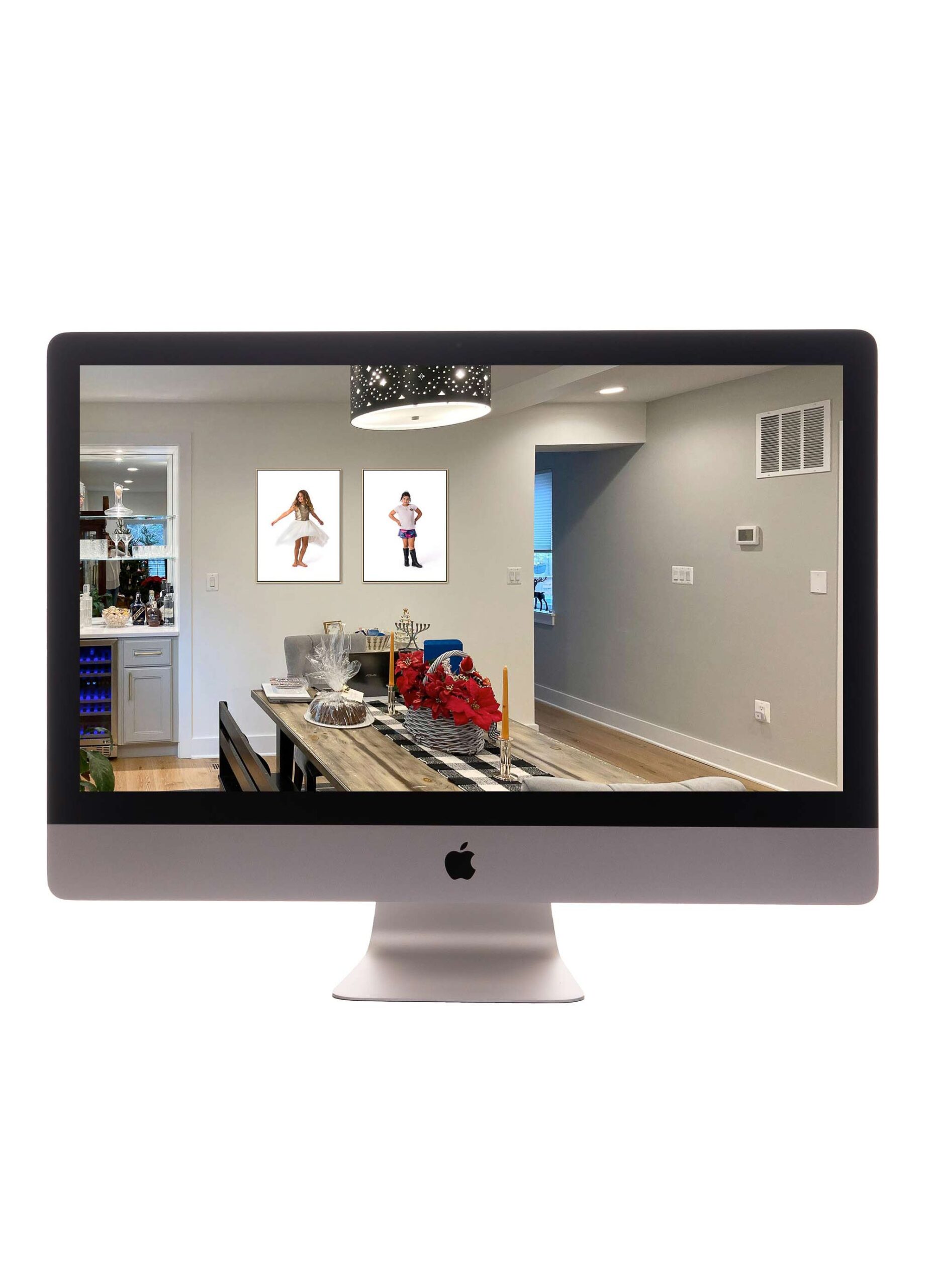 Modern family room with two framed portraits of children hanging above a console table with red flowers and decorative items